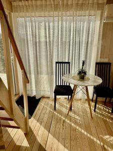 a table and chairs in a room with a window at Kadaksalu with sauna hinnas in Ruu
