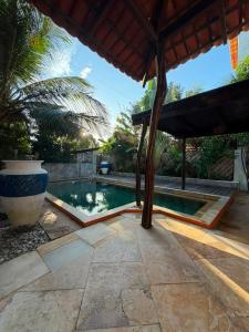 a swimming pool in a backyard with a pavilion at Villa Cajuiero Inn in Prea