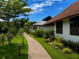 a walkway next to a house with a yard at Chaiyo Riverfront Resort Phuket in Phuket