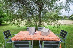 a wooden table with four chairs and a tree at Bettenays Margaret River in Metricup