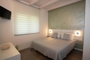 a bedroom with a bed with white sheets and a window at Casa Terry in Ronchi dei Legionari