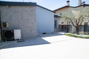 a building with a gate and a tree next to it at Casa Terry in Ronchi dei Legionari +8 photos