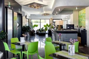 ein Restaurant mit neongrünen Stühlen und Tischen in der Unterkunft Hotel Côte D'Est in San Foca