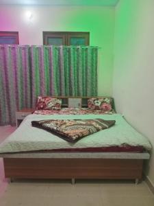 a bed in a bedroom with green curtains at Cosy Paradise in Ādbadri