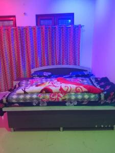 a bed in a room with red and blue curtains at Cosy Paradise in Ādbadri