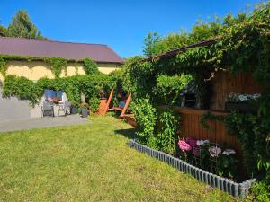 a yard with a fence and some chairs and flowers at Przystanek Żarnowska Domki in Żarnowska