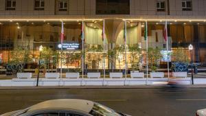 a car parked on a street in front of a building at Corp Executive Hotel Doha Suites in Doha