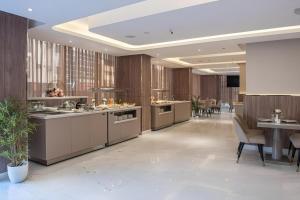 a large kitchen with wooden walls and a table and chairs at Corp Executive Hotel Doha Suites in Doha