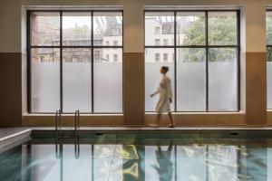 a woman walking by a swimming pool at Apex Grassmarket Hotel in Edinburgh