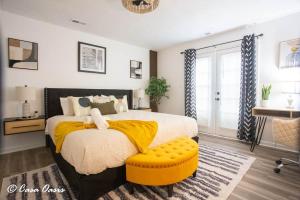 a bedroom with a large bed with a yellow blanket at Madison Luxury 4BR Theater Arcade Firepit in Madison