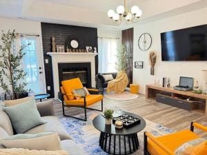 a living room with orange furniture and a fireplace at Madison Luxury 4BR Theater Arcade Firepit in Madison