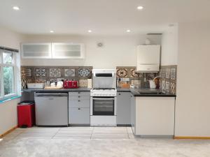 a kitchen with white appliances in a room at Studio Lodge in Crowhurst +2 photos