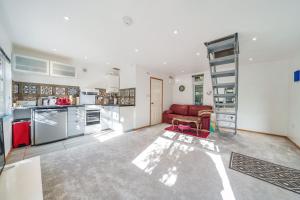 a large kitchen with a red couch in a room at Studio Lodge in Crowhurst