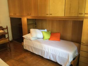 a bed with two colorful pillows on it in a room at Diana Apartment Savona in Savona