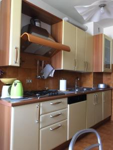 a kitchen with wooden cabinets and a stove top oven at Diana Apartment Savona in Savona