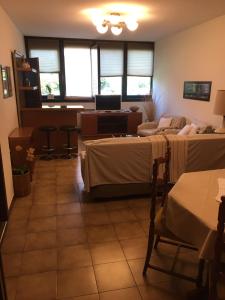 a room with two beds and a desk with a laptop at Diana Apartment Savona in Savona