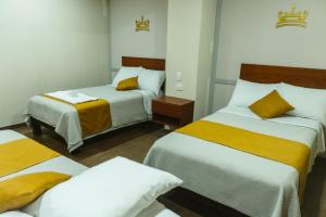 a bedroom with two beds with yellow and white sheets at El Sueño Del Rey in Majes