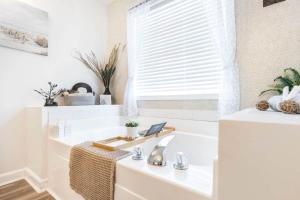 a white bathroom with a sink and a window at Sunrise Tranquil Cottage 3BR RAFB Pet Friendly in Warner Robins