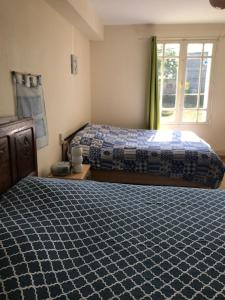 a bedroom with two beds and a window at Maison de campagne in Clessé