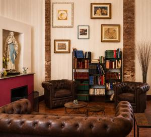 a living room with a leather couch and bookshelves at Domus Ciliota in Venice