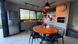 a kitchen with a wooden table and chairs in a kitchen at BELA VISTA RESERVAs in Petrópolis