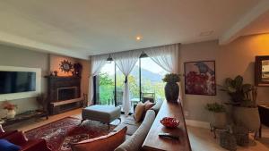 a large living room with a couch and a tv at BELA VISTA RESERVAs in Petrópolis