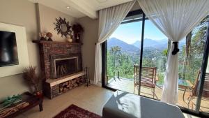 a living room with a fireplace and a large window at BELA VISTA RESERVAs in Petrópolis