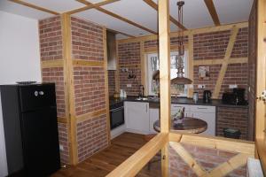 a kitchen with a brick wall and a black refrigerator at Live your dream in Kirchberg