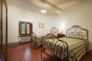 a bedroom with two beds and a fireplace at Castello di Albola in Radda in Chianti