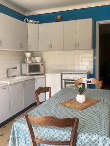 a kitchen with a table and a kitchen with white cabinets at Maison de campagne in Clessé