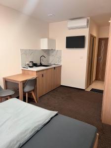 a room with a bed and a kitchen with a sink at Aura Pokoje na Wynajem in Wojnicz