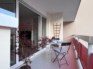 a small balcony with a table and chairs on it at Eden-Novia in Orléans