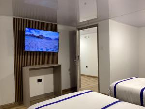 a hotel room with two beds and a flat screen tv at Paramount Hotel in Bogotá