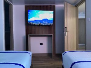 a room with two beds and a flat screen tv at Paramount Hotel in Bogotá +16 photos