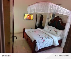 a bedroom with a bed with a canopy at JA Haven Suite in Lira +2 photos