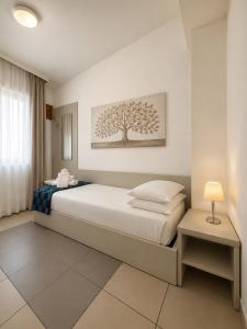 a bedroom with a bed with a tree picture on the wall at Domus Ciliota in Venice