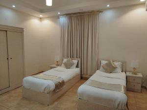 dwa łóżka w pokoju hotelowym withermottermottermott w obiekcie مساكن المبيت 1 w mieście Abha