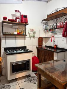 a kitchen with a stove and a table in it at Aconchego Central in Tiradentes
