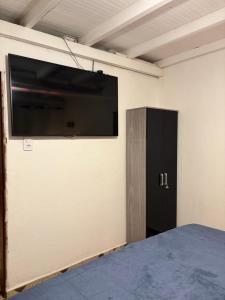 a flat screen tv on a wall in a room at Aconchego Central in Tiradentes