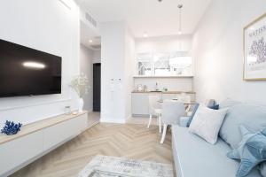 a living room with a couch and a tv at Olsztyn Kapitańska 2 in Olsztyn