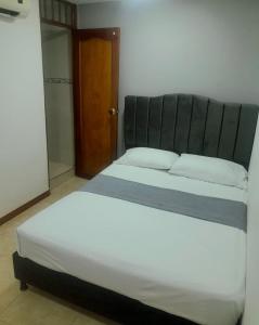 a bedroom with a large bed with a black headboard at Hotel Santander Plaza in Neiva