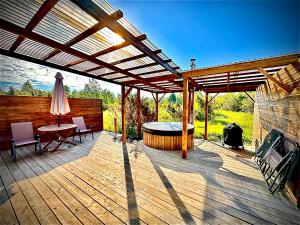 a wooden deck with a table and a umbrella at Kadaksalu with sauna hinnas in Ruu