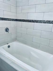 a white bath tub in a white tiled bathroom at Economic Apartments & Rooms next to the beach in Cancún +60 photos
