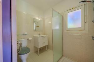 a bathroom with a toilet and a sink and a shower at Appartement Lilas - Résidence Kiwi in Aytré