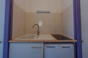 a kitchen with a sink and a counter top at Appartement Lilas - Résidence Kiwi in Aytré