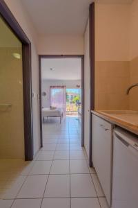 a kitchen with a hallway leading to a patio at Appartement Lilas - Résidence Kiwi in Aytré