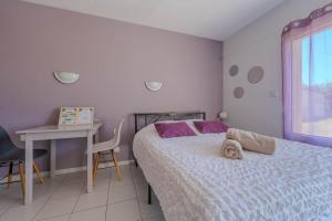 a bedroom with a bed and a desk and a window at Appartement Lilas - Résidence Kiwi in Aytré
