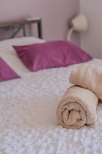 a towel sitting on top of a bed at Appartement Lilas - Résidence Kiwi in Aytré +28 photos