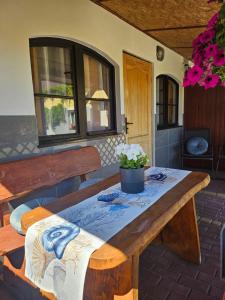 a wooden table with a potted plant on a patio at Przystanek Żarnowska Domki in Żarnowska