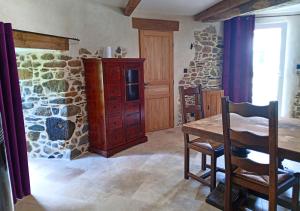 a kitchen with a wooden table and a stone wall at La Synchronicité - Chambres d'Hôtes in Vaudrimesnil